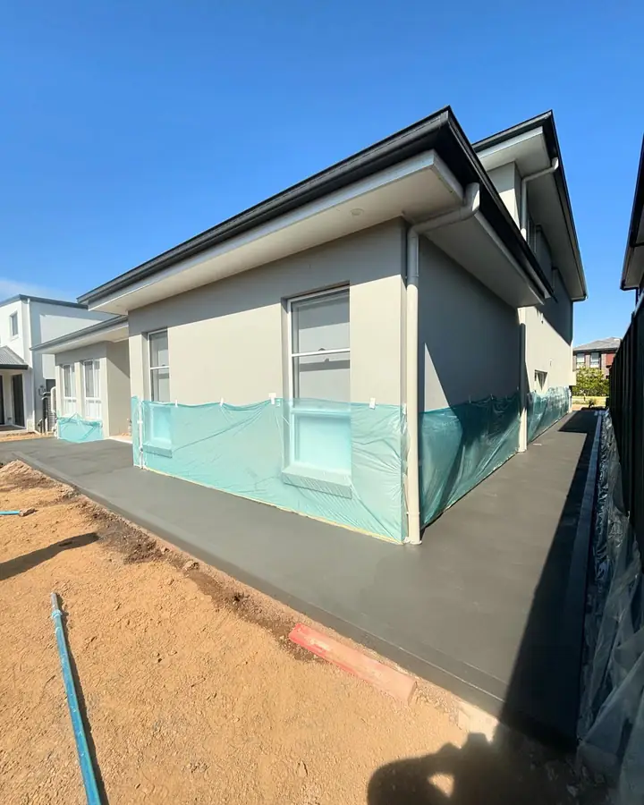 Charcoal path wrapping around the side of a new house