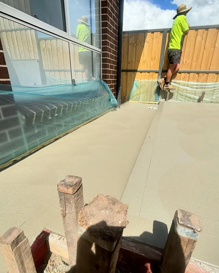 Crew finishing backyard slab
