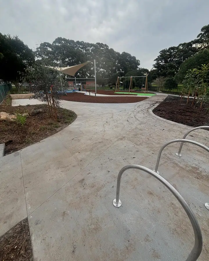 Curved concrete path through a public playground